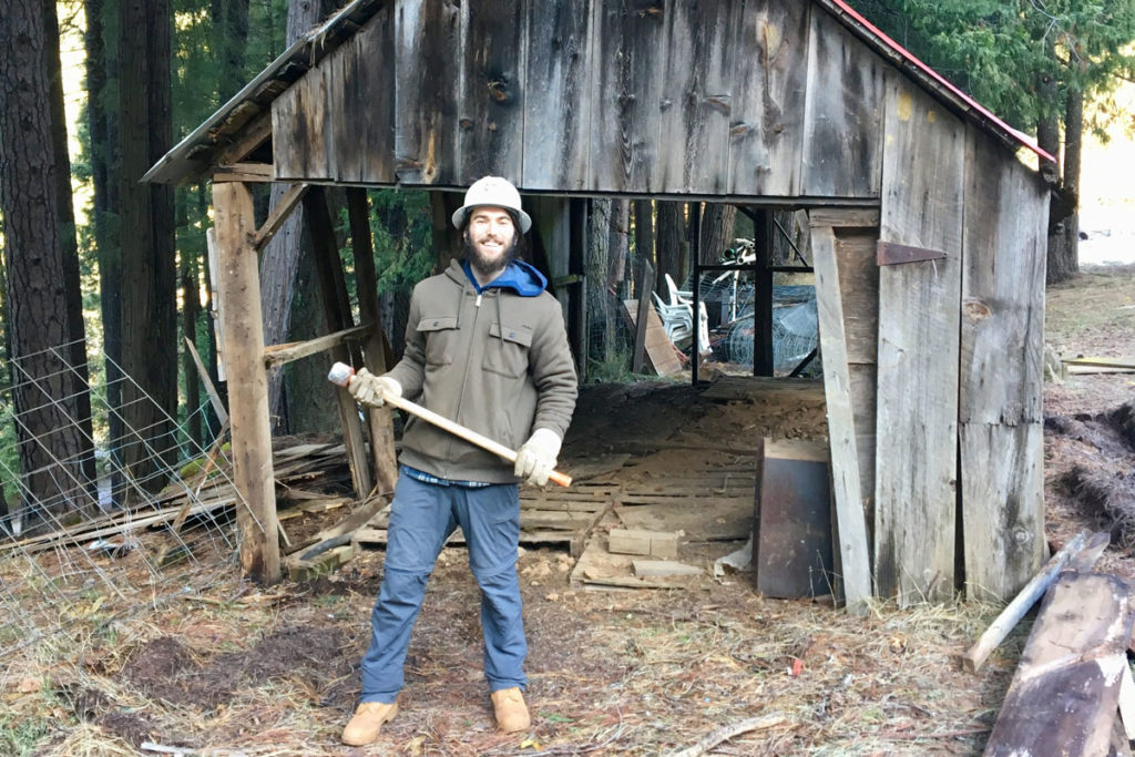 Nick with hammer in front of old barn