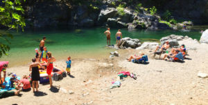 Families at river swimming hole beach